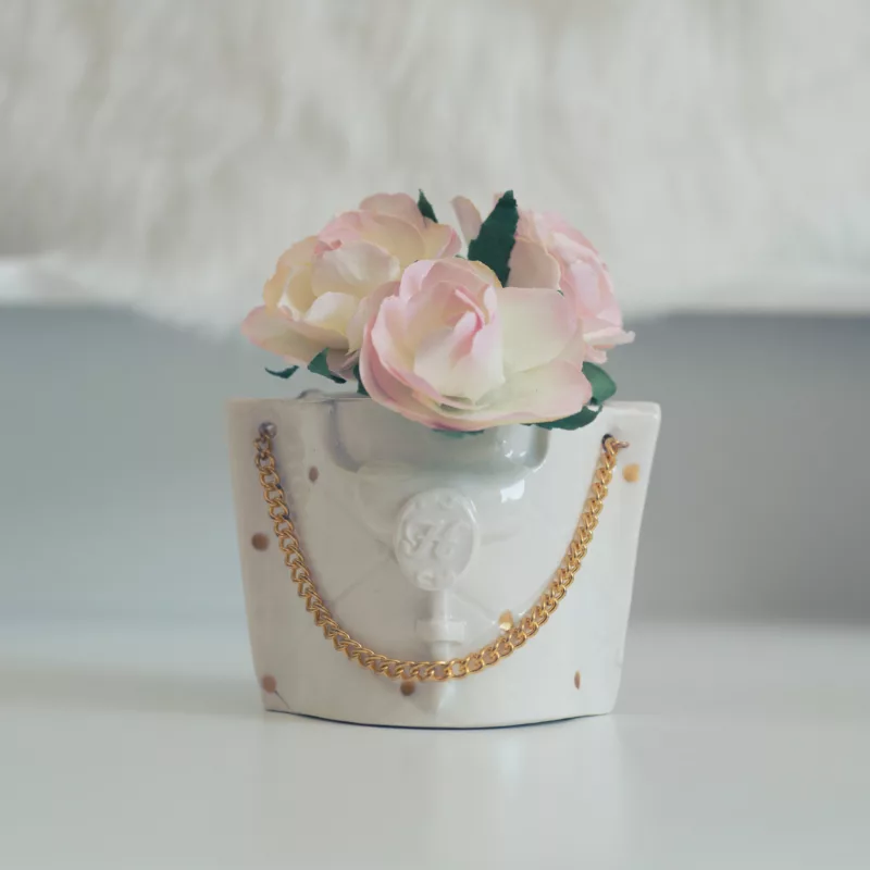 Mini Tasse en porcelaine blanche, luxueuse, avec un aspect capitonné, orné d'une bandoulière en métal doré, présenté avec des fleurs rose pastel